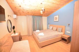 a bedroom with a large bed and a couch at Studios Sotiria in Limenas