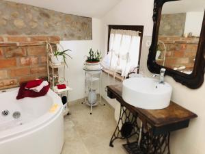 ein Badezimmer mit einer Badewanne, einem Waschbecken und einem Spiegel in der Unterkunft GardaBeds Adults Only in Castelnuovo del Garda
