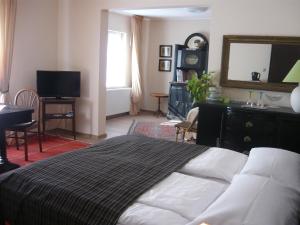 1 dormitorio con cama, escritorio y espejo en Mandula ház, en Veszprém