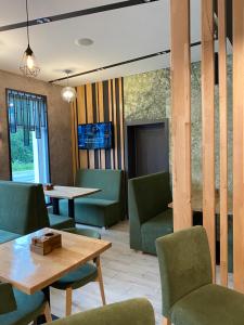 restauracja z zielonymi krzesłami i drewnianym stołem w obiekcie Geldberg w mieście Tatarów