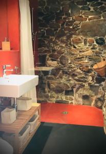 a bathroom with a sink and a stone wall at Le 30 in Troistorrents