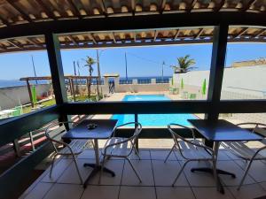 a patio with chairs and a table and a swimming pool at Casarão da Praia - Itaipuaçu, Jardim Atlântico, Maricá in Itaipuaçu