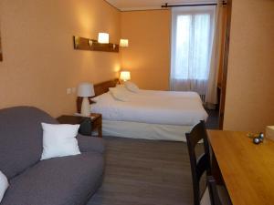 une chambre d'hôtel avec deux lits et un canapé dans l'établissement Logis Hôtel Restaurant Belle Rive, à Najac