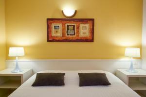 una camera con un letto bianco e due lampade di Logis Hôtel Le Belle Rive a Najac