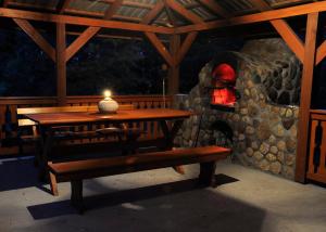 a wooden table and bench with a candle on a patio at Leśny Dworek in Kryłatka
