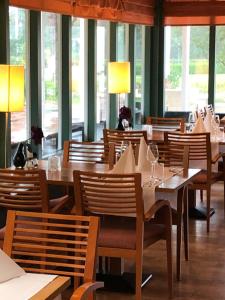 a restaurant with wooden tables and chairs and windows at Appartement 134 - Waddengeluk Resort Amelander Kaap! in Hollum