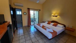 a bedroom with a large bed and a television at Hotel LunaSol in Playa del Carmen