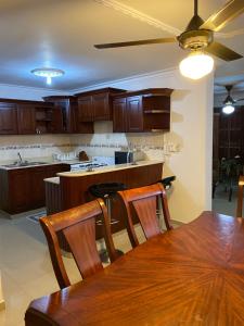 a kitchen with wooden cabinets and a wooden table at 1Dom Rep - Huge cozy 3 bedrooms - close to all transportation Jacobo Majluta - Residencial Paradise V Colina Arroyo 1 in Santo Domingo