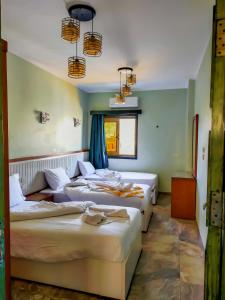 three beds in a room with blue walls at Geo Palace in Dahab