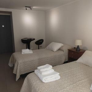 a hotel room with two beds with white sheets at Departamento Santiago Centro, Excelente ubicación in Santiago
