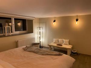 1 dormitorio con cama, mesa y luces en Le Retour aux Sources - Chambre d'Hôte chaleureuse et conviviale en Chaudfontaine