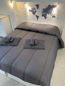 ein großes Bett mit zwei Paar Schuhen drauf in der Unterkunft Bed and Beach in Messina