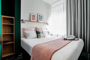 ein Schlafzimmer mit einem großen weißen Bett und einem Fenster in der Unterkunft Republik Hotel in Lyon + 32 Fotos