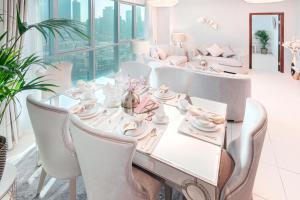 a dining room with a white table and chairs at Elite Royal Apartment - Full Burj Khalifa & Fountain view - Ambassador in Dubai