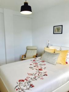 - une chambre avec un grand lit blanc et un couvre-lit floral dans l'établissement Hauzify I Apartamento Ruiz de Padron, à San Sebastián de la Gomera