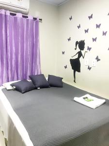 Quarto - Condomínio في ماكابا: غرفة نوم مع سرير مع فراشات على الحائط