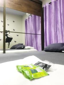 a bedroom with two beds with purple curtains at Quarto - Condomínio in Macapá