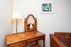 a mirror on a wooden table next to a couch at The Inn @ Aird a' Bhasair in Ardvasar
