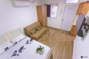 エイラットにあるOrel's Ground floor Apartmentのベッド1台とソファが備わる小さな客室です。
