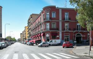 a red building with cars parked on the side of a street at Hotel Nuvò in Naples