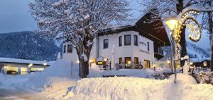 uma casa coberta de neve à noite em Pension Gasthof Gaistal em Leutasch