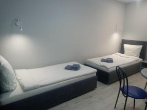 two beds in a room with a table and chairs at Apartament YesCity! in Uzhhorod