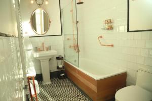y baño con bañera, aseo y lavamanos. en Fortunata Chacana Guest House, en Valparaíso