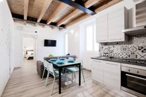 una cucina e un soggiorno con tavolo e divano di Spazio 77 - The House Of Travelers a Como