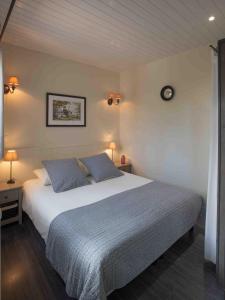 a bedroom with a large bed with two blue pillows at L'Eden Weiss in Magny-les-Hameaux