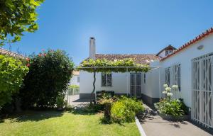 a house with a garden with a pergola with flowers at Casa Tradicional da Vila in Vila Franca do Campo