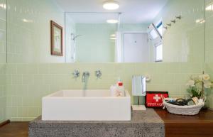 a bathroom with a white sink and a mirror at Casa Tradicional da Vila in Vila Franca do Campo +36 photos