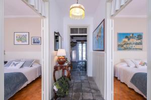 a hallway with two beds in a white room at Casa Tradicional da Vila in Vila Franca do Campo