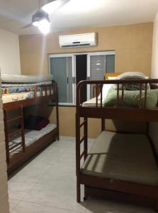 une chambre avec deux lits superposés et une fenêtre dans l'établissement Apt frente para o mar - Prainha, Arraial do Cabo, à Rio de Janeiro