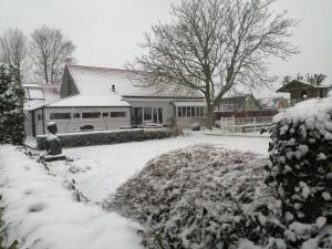 um quintal coberto de neve com uma casa em tende em Deerlijk