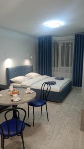 Schlafzimmer mit einem Bett, einem Tisch und Stühlen in der Unterkunft Apartament YesCity! in Uschhorod
