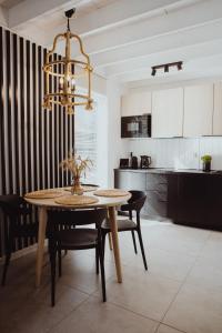 a kitchen with a table and chairs and a chandelier at Forest House Pobierowo in Pobierowo