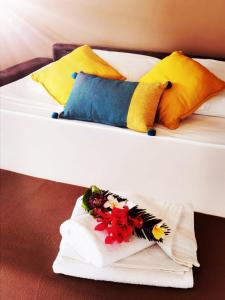 two beds with colorful pillows and a flower arrangement on them at Habitation Noelesse in Beauregard