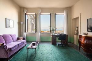 uma sala de estar com um sofá roxo e uma mesa em Marina Piccola 73 em Sorrento