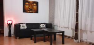 a living room with a black couch and a table at Goldapartman Salgótarján in Salgótarján