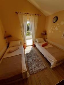 two beds in a room with a window at Holiday Home Subasic in Zlarin