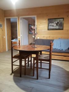 a wooden table and chairs in a room at Les Chalets de la Garenne in La Ferté-Beauharnais +2 photos