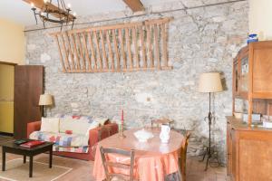 ein Wohnzimmer mit einem Tisch und einer Steinmauer in der Unterkunft Les Gîtes du Domaine Grand Guilhem in Cascastel-des-Corbières