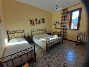 1 Schlafzimmer mit 2 Betten und einem Fenster in der Unterkunft L'Agrifoglio di Emy in Guspini