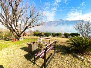 a bench in a field with a mountain in the background at Hotel Sanjeevny in Bajaura
