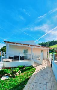 ein weißes Haus mit einer Veranda und einem Zaun in der Unterkunft JANAS Country House in Castelsardo