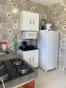 uma cozinha com um frigorífico branco e um micro-ondas em Hospedaria Ilhabela - Flats Sul em Ilhabela