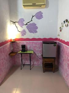 a room with a table and a wall with purple flowers at Posada los abuelos in Holbox Island