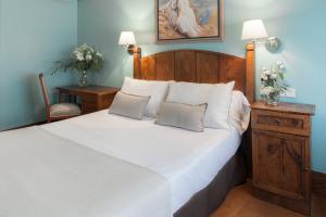 a bedroom with a large white bed with two pillows at La Galería in Donostia-San Sebastián