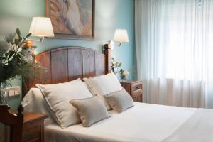 a bedroom with a bed with white sheets and pillows at La Galería in Donostia-San Sebastián
