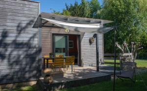 una pequeña casa con una mesa y sillas en una terraza en L'Eden Weiss en Magny-les-Hameaux